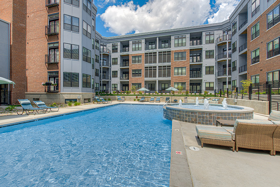 Apartment swimming pool with deck seating and fountains