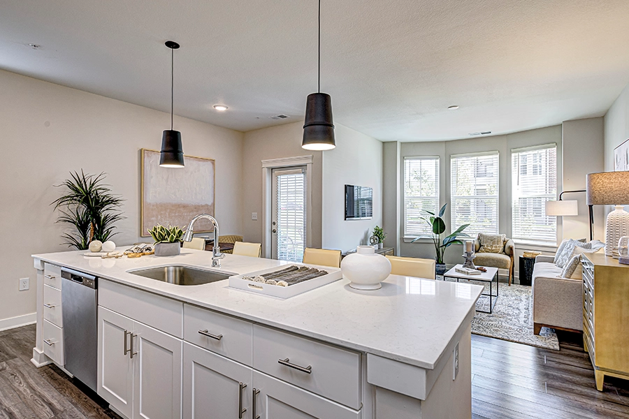 Kitchen island in an upscale apartment with main living area in the background